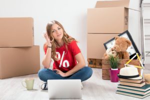 young lady moving new house concept wearing red t shirt with discount symbolSwissLogistik Zuegelunternehmen der Schweiz