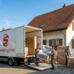 SwissLogistik LKW vor einem Wohnhaus in Wetzikon, blauer Himmel, professionelles Umzugsteam