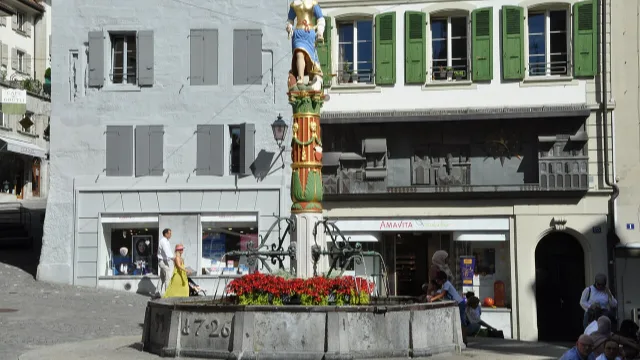 Umzug in Lausanne – Bildmotiv: Place de la Palud mit dem Justitia-Brunnen